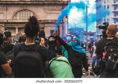 Panama City, Panama; June 23 2021: Protesters In Front Of Panama´'s National Congress With Blue Smoke Flare