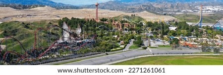 Panaroma of an Six Flags Magic Mountain Six Flags Hurricane Harbor Valencia amusement park roller coaster rides green background and mountain. Horizontal banner background