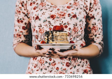 Pancake with chocolate and strawberry in woman hands
