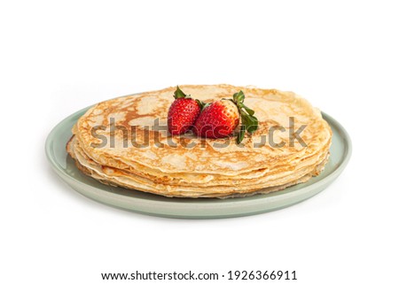Pancake on green plate on white background. Many pancakes are stacked. Thin pancakes with crispy crust. Maslenitsa. Pancakes for breakfast and carnival. Food background.