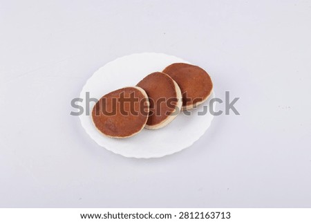 Pancake Stack with Browned Surface and Creamy Rim on White Plate, Studio Food Photo on Light Background