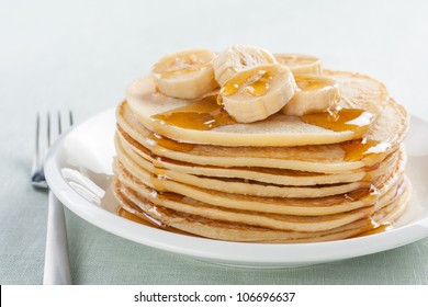 pancakes with banana and syrup on white plate - Powered by Shutterstock