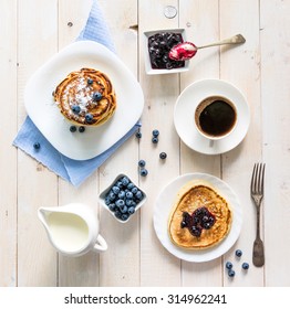 pancakes with blueberry and coffee on wooden background. top view