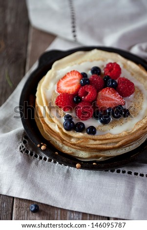 Similar – Foto Bild Pfannkuchen mit Johannisbeeren und Blaubeeren in gusseiserner Pfanne stehen auf dunklem Tisch