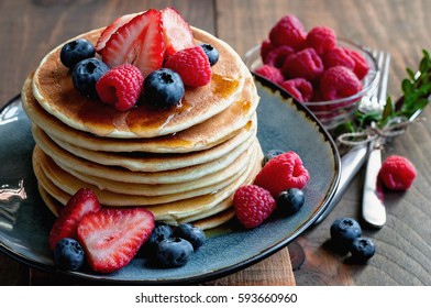 Pancakes with fresh berries and maple syrup for breakfast, selective focus, toned image - Powered by Shutterstock