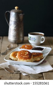 pancakes with jam, on a white plate, and a cup of coffee