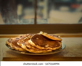 Pancakes on a window pane. Room for text top and side. Warm tones.