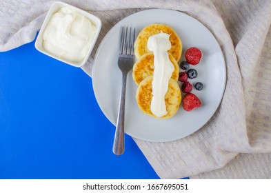 Pancakes With Sour Cream Frozen Blueberries And Raspberries.