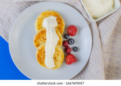 Pancakes With Sour Cream Frozen Blueberries And Raspberries.