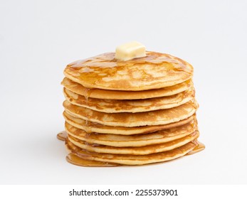 Pancakes stack with melting butter piece and pouring honey. Close up view. Wite background. Maslenitsa concept. Crepes week. Delicious homemadу breakfast or lunch.