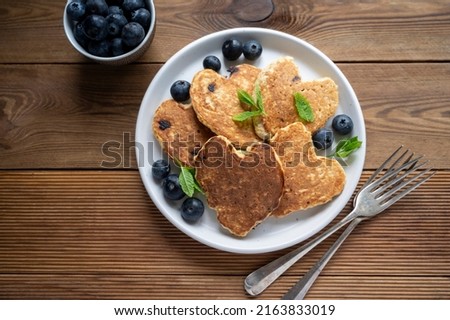 Pancakesheart shaped with fresh blueberries, Morning breakfast, delicious vegan pancakes. Rustic, woodenbackground