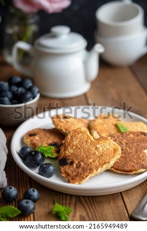 Pancakesheart shaped with fresh blueberries, Morning breakfast, delicious vegan pancakes. Rustic, woodenbackground.