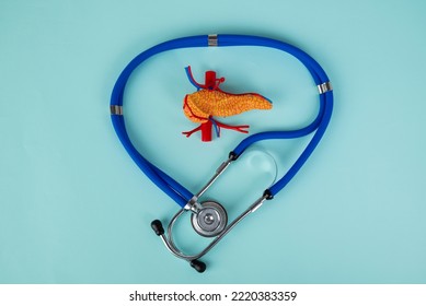 pancreas and stethoscope lies on a blue background - Shutterstock ID 2220383359