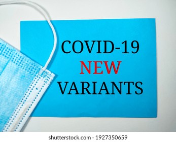 Pandemic concept.Text COVID-19 NEW VARIANTS on blue and white background with face mask. - Shutterstock ID 1927350659