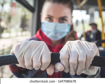 Pandemic COVID-19. A woman in a medical mask and gloves rides public transport bus. Prohibition of free movement. Social distance. Coronavirus quarantine in Europe.