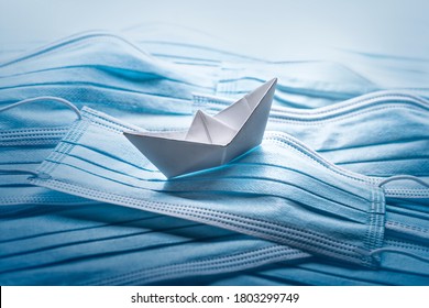 Pandemic problems concept, origami ship with surgical masks. - Shutterstock ID 1803299749