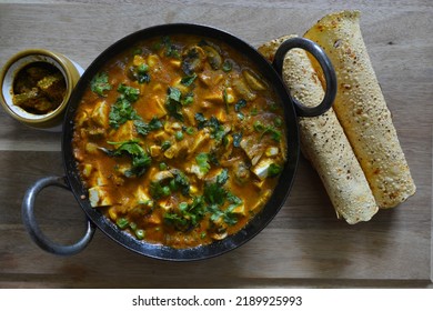 Paneer Curry In An Iron Kadhai, An Indian Cuisine With Papad And Pickle