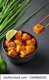 Paneer Manchurian Or Paneer 65 In Bowl At Black Concrete Background. Paneer Manchurian Is Indian Chinese Cuisine Dish With Panner Cheese, Tomatoes, Onion, Soy Sauce.