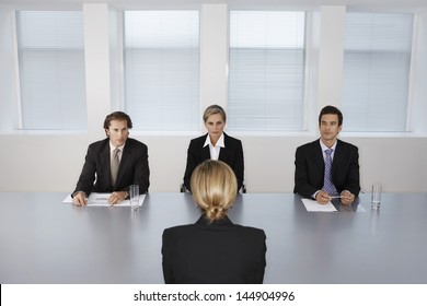 Panel of business people conducting job interview with female candidate - Powered by Shutterstock