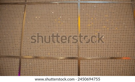 panel filled with numerous small circular objects arranged in a grid pattern. Each circle, possibly a capsule or container, is housed in its own compartment, creating an organized structure. The objec