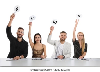 Panel Of Judges Holding Different Score Signs At Table On White Background