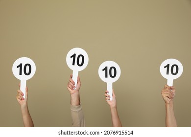 Panel of judges holding signs with highest score on beige background, closeup - Shutterstock ID 2076915514