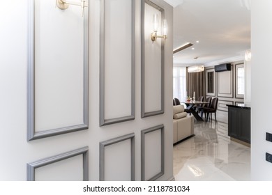 The panel is a plaster frame with patterned corners on the wall of the room. Interior design. Loft with baroque elements. Beige-brown shades.