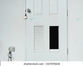 A Panel Of Public Toilet Door Is Missing.  A Dark Hole Shows At The Bottom Right Side.  The Locked Door Is Dusty And Dirty.  It Needs To Be Repaired And Renovated. 