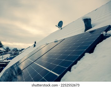 panel at rooftop with snow. removing snow off solar panels in winter. Removing snow photovoltaic system - solar cells. snow covers panels - no producing power. energy efficiency  - Shutterstock ID 2252552673