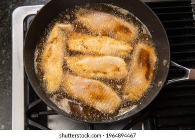 Pan-frying or home cooking fish fillet on a stove top.