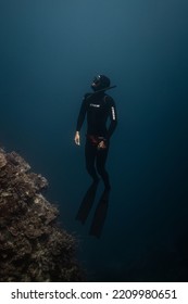 Panglao, Philippines - 28.04.2022: Male Freediver Wearing Wetsuit Ascending To The Surface Holding Breath In The Sea Ocean