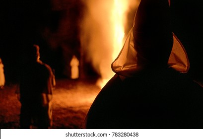 Panhandle Area, Florida, United States -
circa 1995 - Ku Klux Klan KKK Night Rally, men Wearing White Robes, hoods, Burning Cross with High Flames, hate, right wing radicals, racism, racists, blacks, 