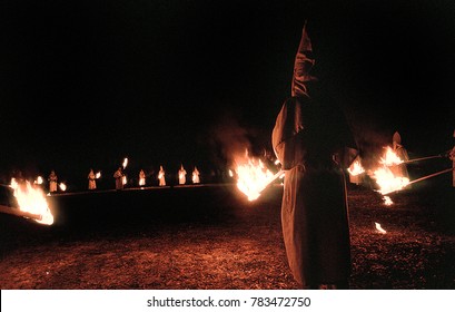 Panhandle, Florida, United States - circa 1995 - Ku Klux Klan KKK Night Ceremony, Members Wearing White Robes, Hoods and Carrying Burning Torches, Standing in a Circle