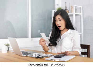 The Panic Asian Woman Checking Expensive Electricity And House Hold Bills, Reads Documents Attentively, Prepares Financial Report, Calculates On Laptop Computer. Finance Interior,domestic Housework 