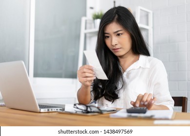 The Panic Asian Woman Checking Expensive Electricity And House Hold Bills, Reads Documents Attentively, Prepares Financial Report, Calculates On Laptop Computer. Finance Interior,domestic Housework 