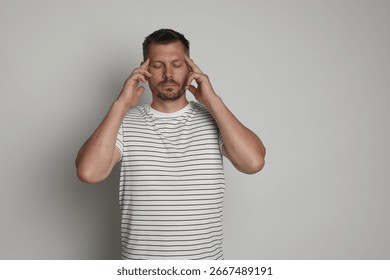Panic attack. Man calming himself down on light grey background, space for text