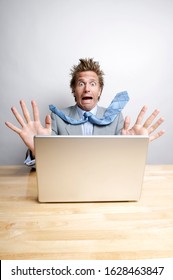 Panicked Office Worker Sitting At His Desk In Front Of His Computer