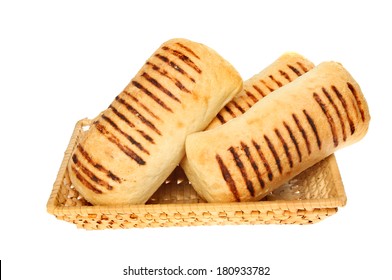 Panini bread rolls in a wicker basket isolated against white