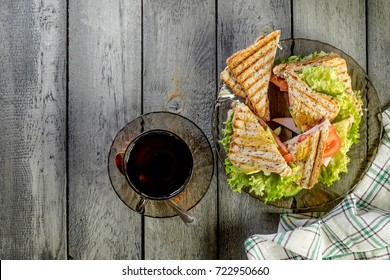 Panini sandwich with ham, tomato and lettuce  on a plate. Top view. Copy space.