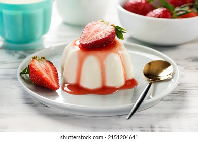 Panna cotta dessert with fresh strawberries and berry sauce.