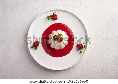 Panna cotta with raspberry syrup, pistachios, berries and mint, high key, top view, close up, copy space 