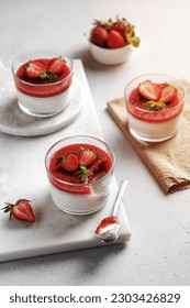 Panna cotta with strawberry in a glass jars decorated with fresh berries and mint, Traditional Italian sweet dessert. Strawberry creamy dessert - panna cotta.