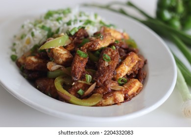 Panner Baby Corn Manchurian. A Crispy And Crunchy Indo Chinese Vegetarian Dish, In A Smooth Gravy With Stir Fried Capsicum And Onions Served Along With Fried Rice. Shot On White Background