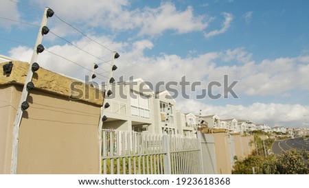 Panning shot of electric fence on a high wall. Property protection, security of residence.