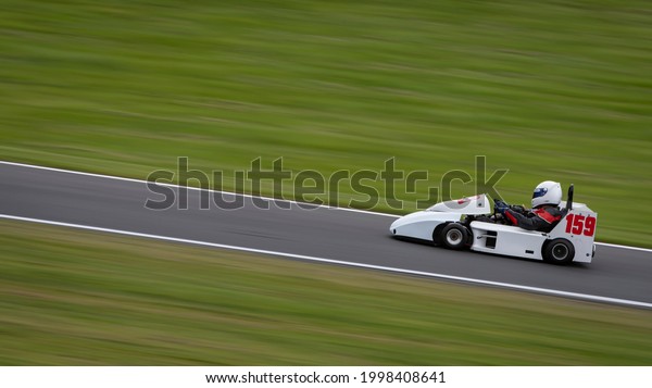 A\
panning shot of a racing kart as it circuits a\
track.