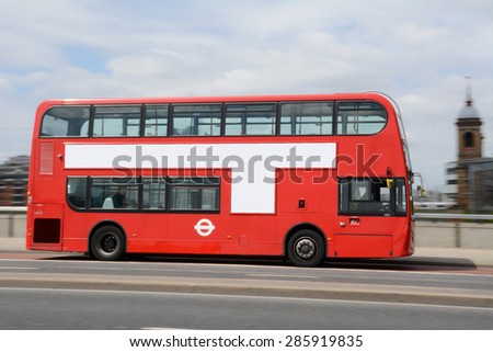 Panning shot of red double decker bus in London.