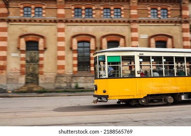 Panning Shot Of Yellow Tram In Milan. Colorful Electric Streetcar In Italy.