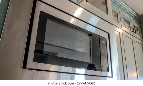 Pano Built In Microwave Oven And Wall Cabinets Inside The Clean Kitchen Of Home. Real Estate Views With Close Up On Appliance And Fixture Of A House.