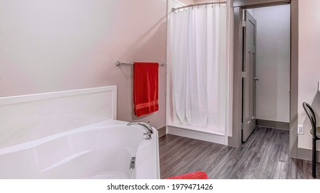 Pano Clean Bathroom With Shower Stall Bathtub And Vanity Area With Bright Lights. Plain White Door, Wooden Floor, And Open Door Can Also Be Seen In This Room.