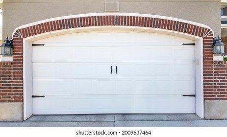 Pano Closed Carriage Style White Garage Door Of A House With Bricks